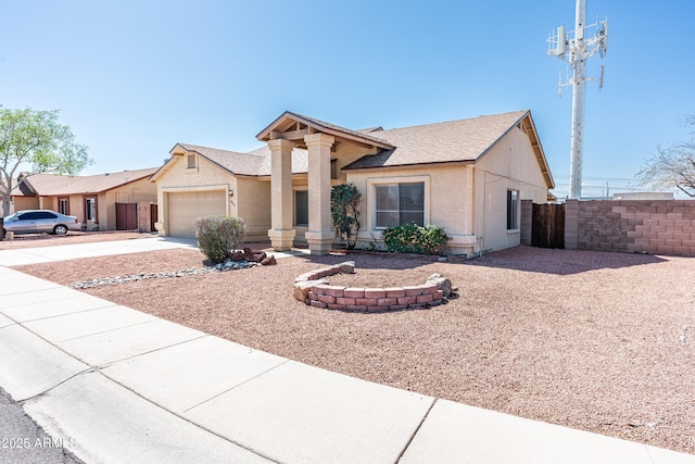 view of front of property featuring stucco siding, concrete driveway, an attached garage, and fence