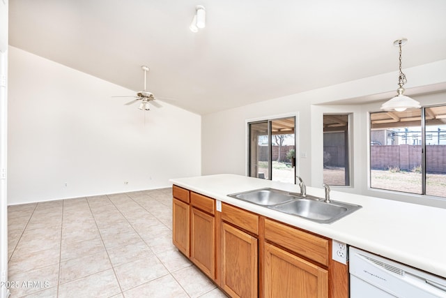 kitchen with hanging light fixtures, light countertops, white dishwasher, and a sink