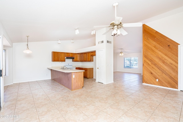 kitchen with open floor plan, white electric range oven, a peninsula, brown cabinetry, and light countertops