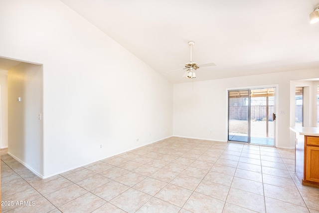 unfurnished room featuring ceiling fan, baseboards, light tile patterned flooring, and vaulted ceiling