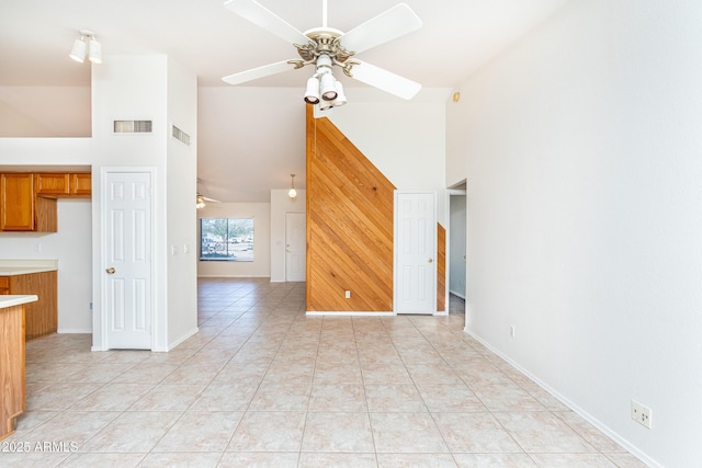 unfurnished living room with light tile patterned floors, visible vents, high vaulted ceiling, and ceiling fan