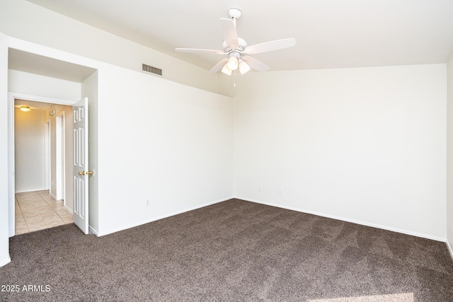 spare room with tile patterned floors, visible vents, a ceiling fan, carpet, and baseboards