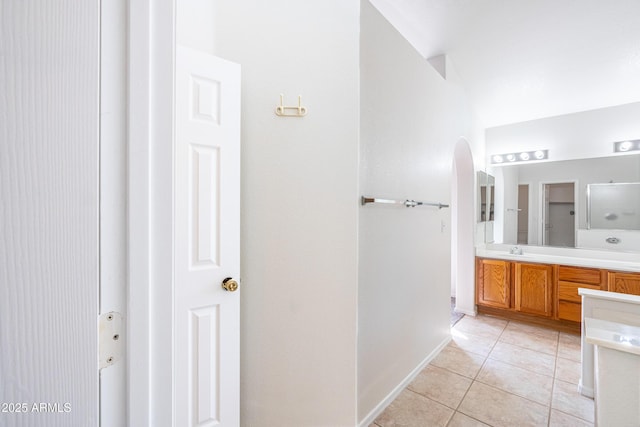 full bath featuring tile patterned floors, a sink, baseboards, and double vanity