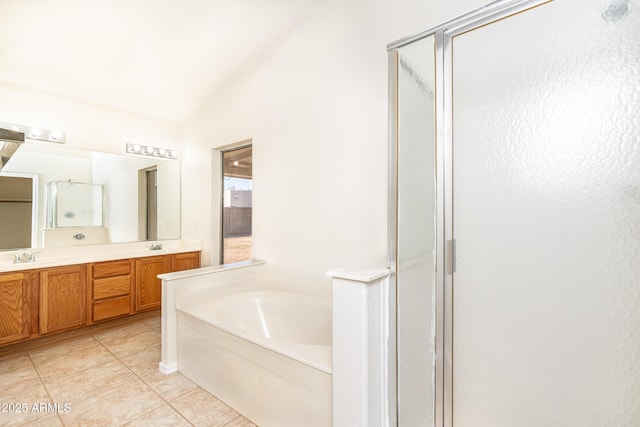 bathroom with tile patterned flooring, lofted ceiling, a garden tub, double vanity, and a stall shower