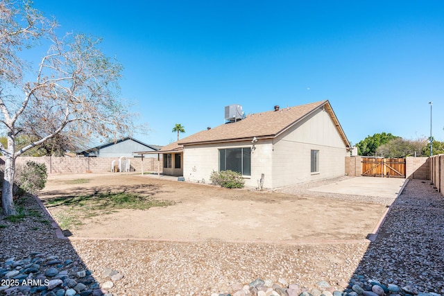 back of house with a gate, central AC, a fenced backyard, and a patio area