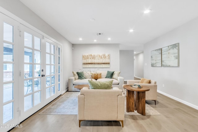 living room featuring french doors and light hardwood / wood-style flooring