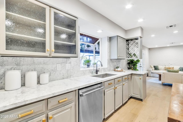 kitchen with gray cabinets, light stone counters, sink, light hardwood / wood-style flooring, and stainless steel dishwasher