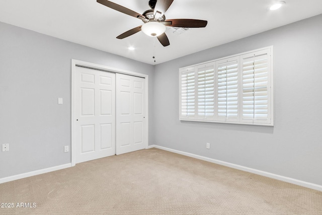 unfurnished bedroom featuring a closet, ceiling fan, and light colored carpet