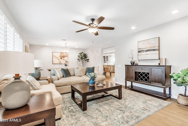 living room featuring ceiling fan and light hardwood / wood-style floors