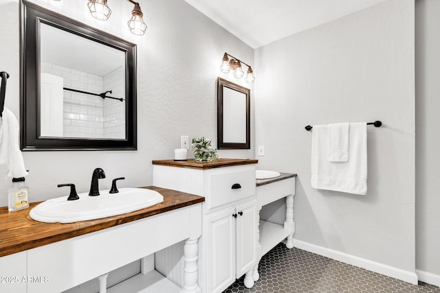 bathroom with tile patterned floors, walk in shower, and vanity