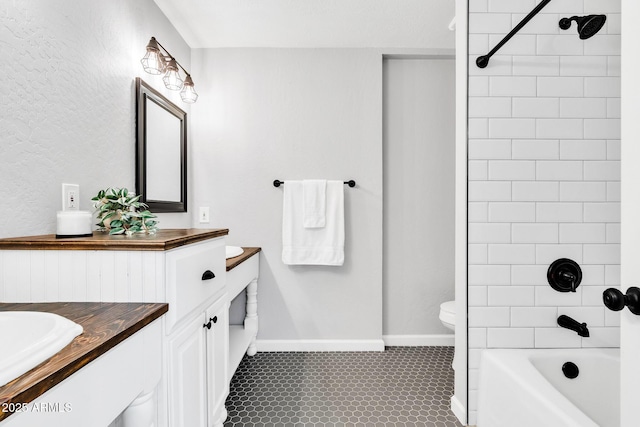 full bathroom with tile patterned flooring, tiled shower / bath combo, vanity, and toilet