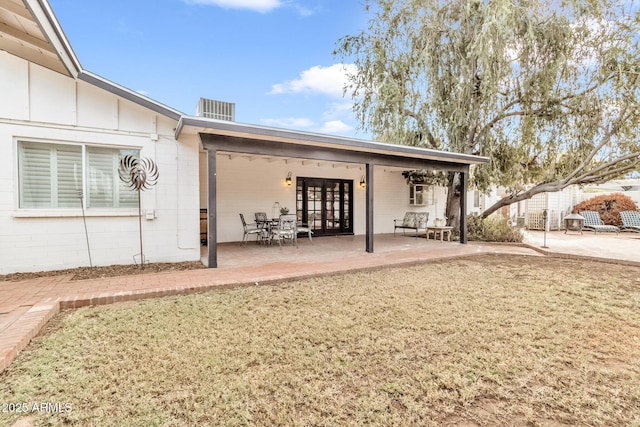 rear view of house featuring a yard, central AC, and a patio area