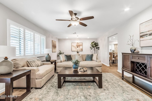 living room with ceiling fan and light hardwood / wood-style flooring