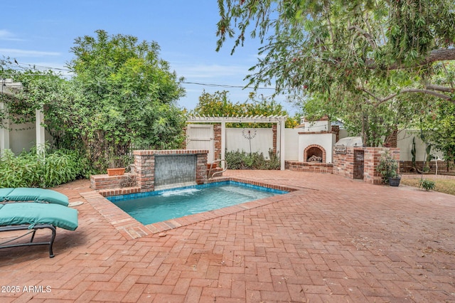 view of pool with a patio, pool water feature, and an outdoor brick fireplace