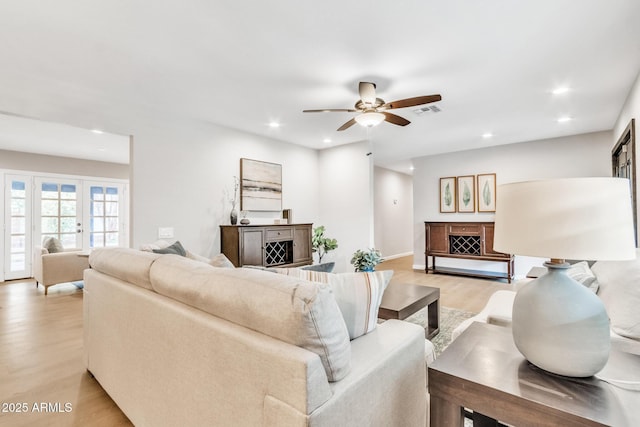 living room featuring light wood-type flooring and ceiling fan