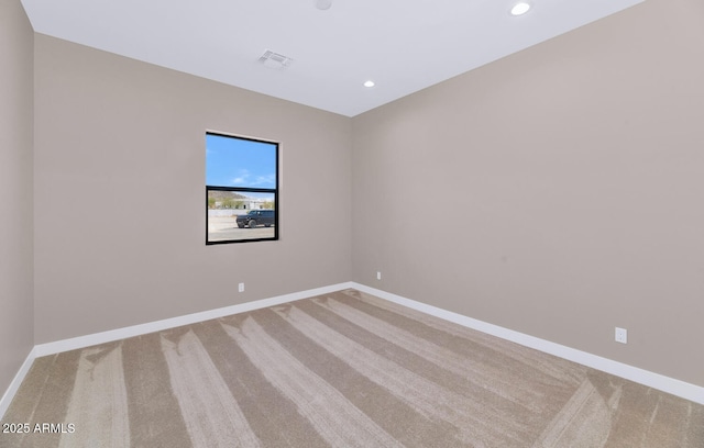 unfurnished room with carpet flooring, visible vents, and baseboards