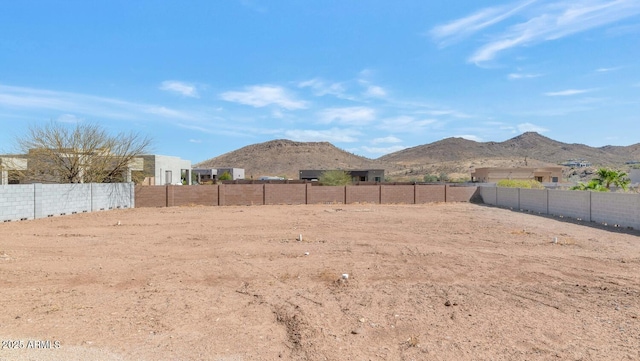 view of yard featuring a mountain view and fence