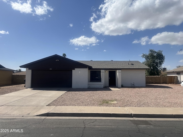 ranch-style house with stucco siding, driveway, fence, roof with shingles, and a garage