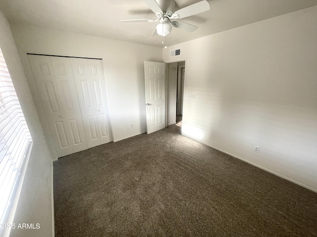 unfurnished bedroom with a ceiling fan, carpet, visible vents, and a closet