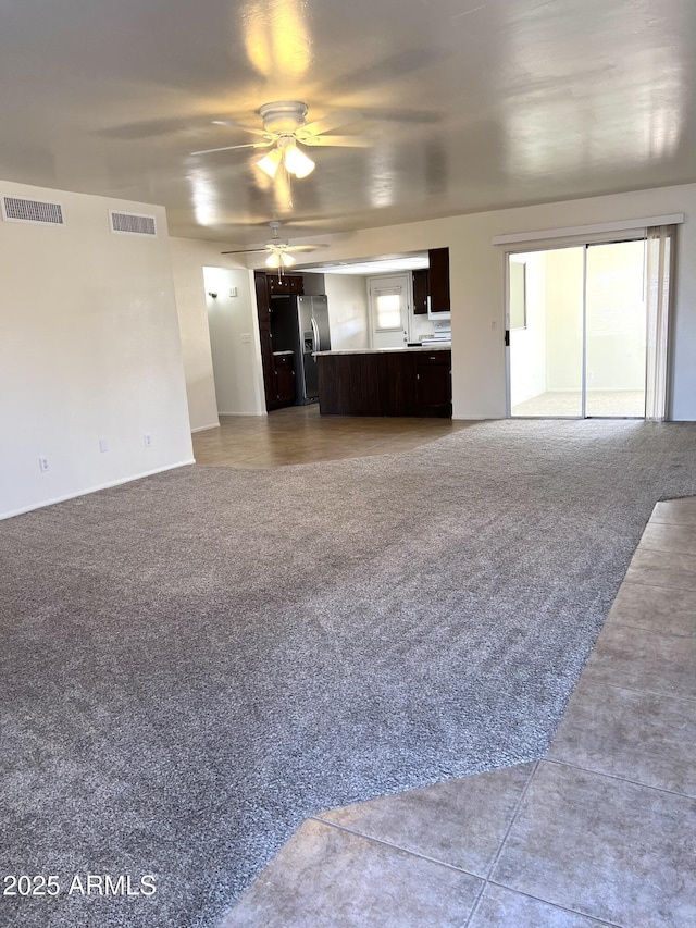 unfurnished living room featuring light carpet, visible vents, and ceiling fan