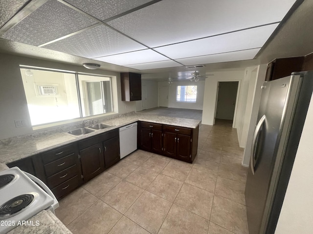 kitchen with dishwashing machine, freestanding refrigerator, ceiling fan, a sink, and dark brown cabinetry