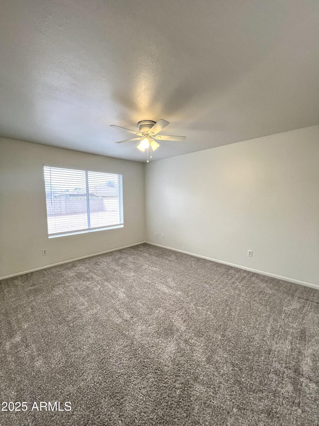 spare room with baseboards, carpet, and ceiling fan