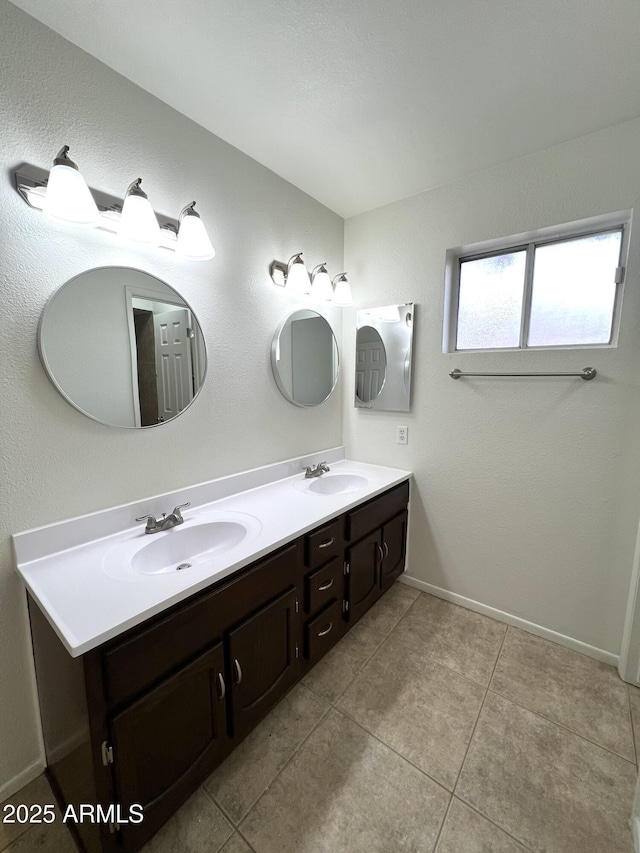 full bath featuring double vanity, baseboards, and a sink