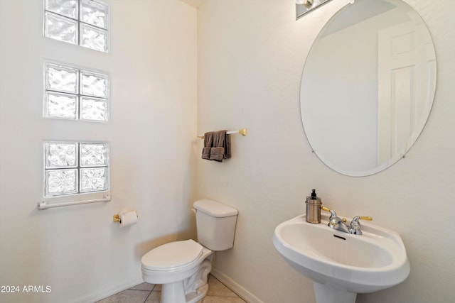 bathroom with toilet, tile patterned flooring, and sink