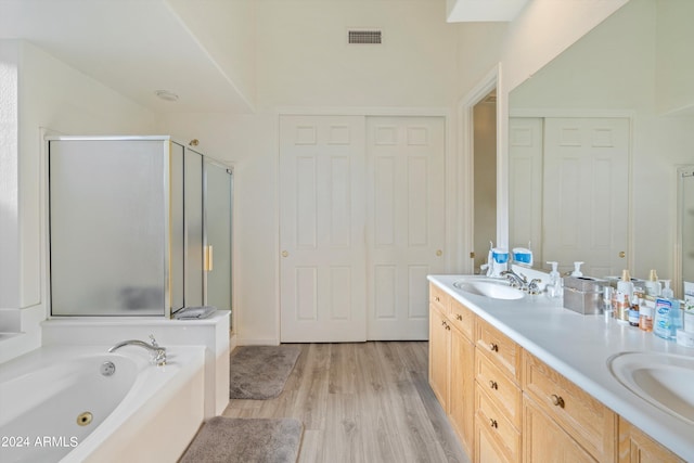 bathroom featuring vanity, independent shower and bath, and hardwood / wood-style flooring