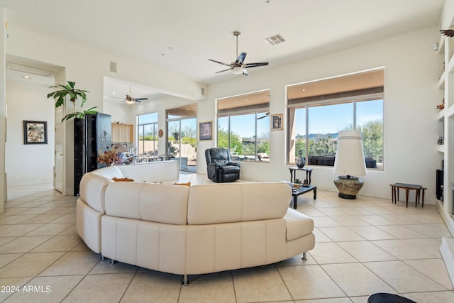 tiled living room with ceiling fan and a healthy amount of sunlight