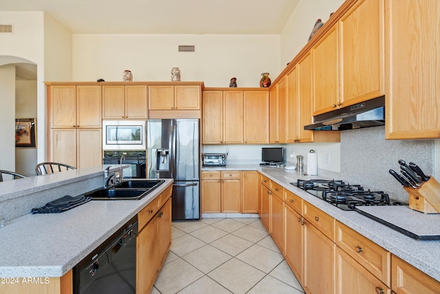 kitchen featuring light stone countertops, black appliances, decorative backsplash, sink, and light tile patterned flooring