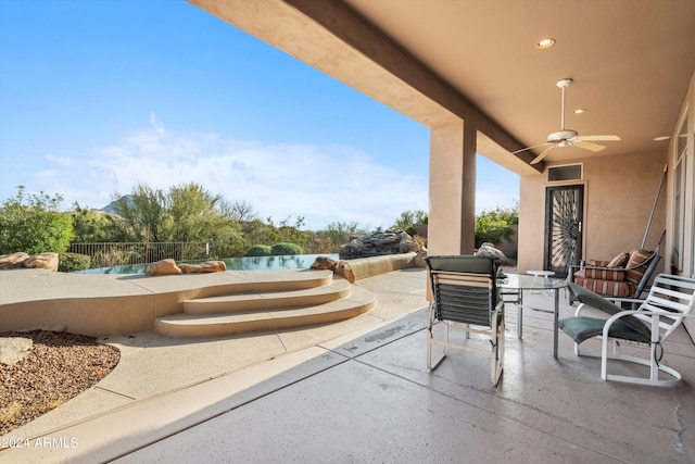 view of patio with ceiling fan and a water view