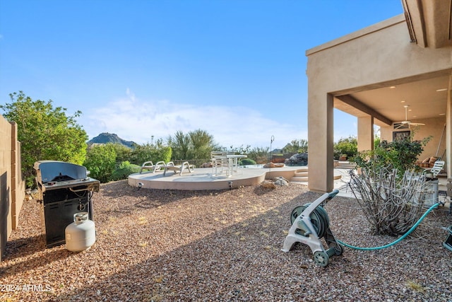 view of yard featuring a mountain view, ceiling fan, and a patio