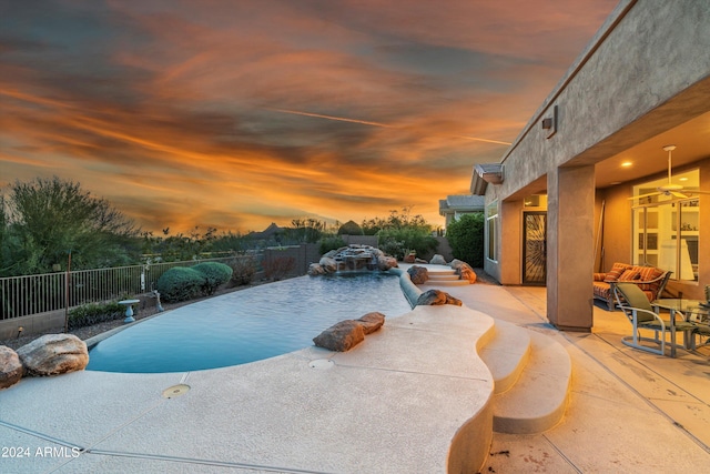 pool at dusk featuring an outdoor hangout area and a patio