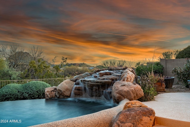 view of pool at dusk