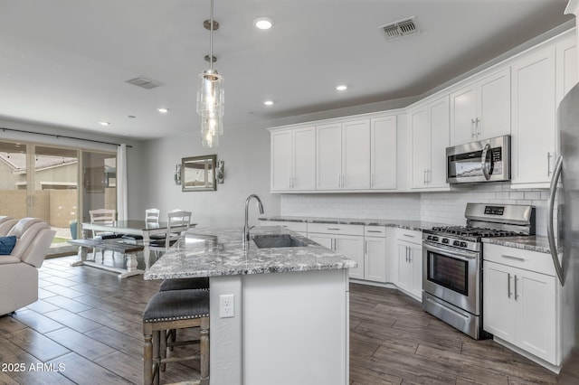 9757 E Red Giant Dr, Mesa, AZ 85212 - kitchen with appliances with stainless steel finishes, a sink, decorative backsplash, white cabinetry, and dark wood-style floors