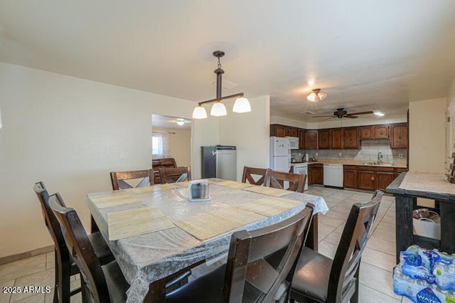 dining space with light tile patterned flooring, sink, and ceiling fan