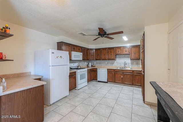 kitchen featuring sink, backsplash, white appliances, ceiling fan, and a textured ceiling