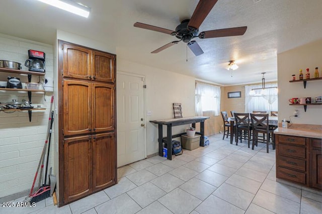 kitchen featuring hanging light fixtures, light tile patterned floors, and ceiling fan