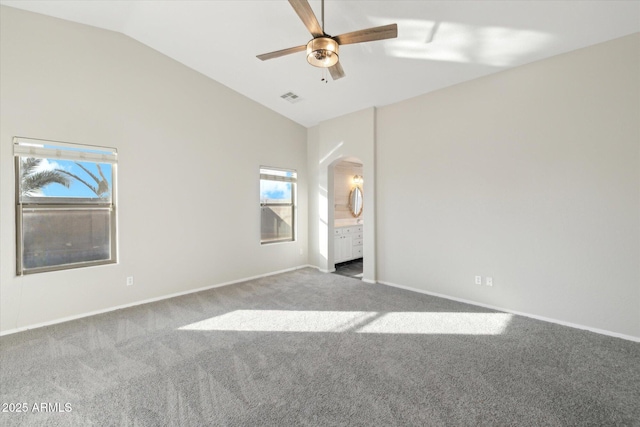 unfurnished bedroom featuring lofted ceiling, ceiling fan, carpet floors, and ensuite bathroom