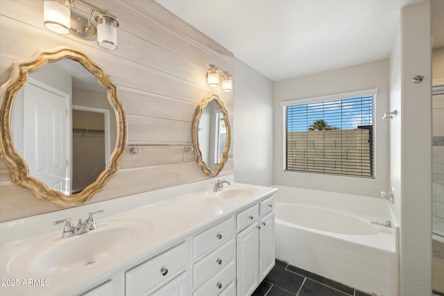 bathroom with vanity, tile patterned flooring, and tiled tub