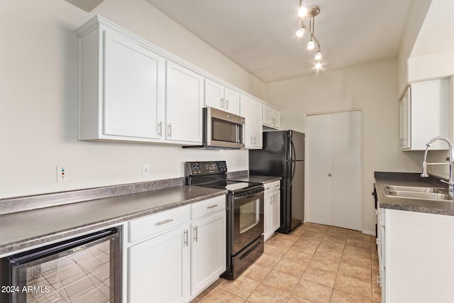 kitchen with sink, beverage cooler, white cabinets, light tile patterned flooring, and black appliances