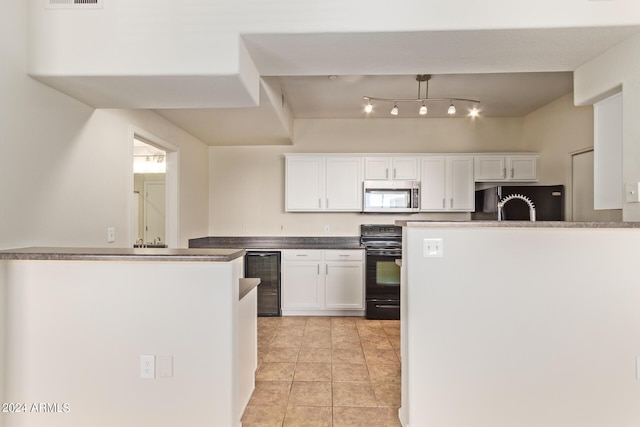 kitchen with decorative light fixtures, white cabinetry, beverage cooler, and black appliances