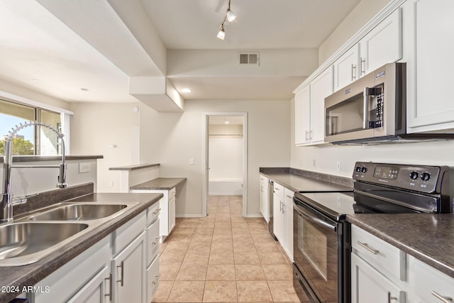 kitchen featuring black range with electric cooktop, track lighting, white cabinetry, and sink