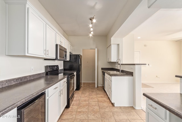 kitchen with appliances with stainless steel finishes, sink, white cabinets, wine cooler, and light tile patterned flooring