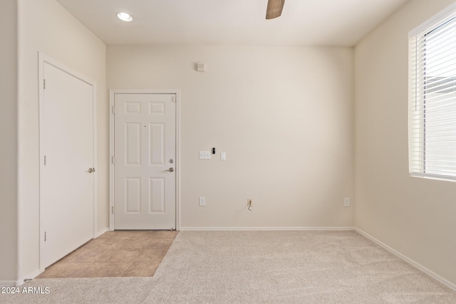 carpeted spare room featuring ceiling fan