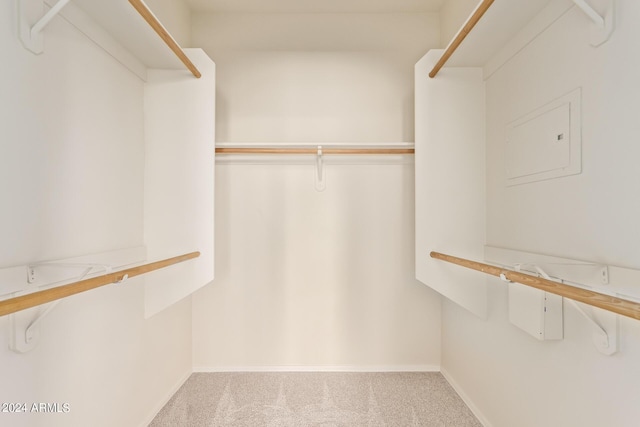 walk in closet featuring light colored carpet