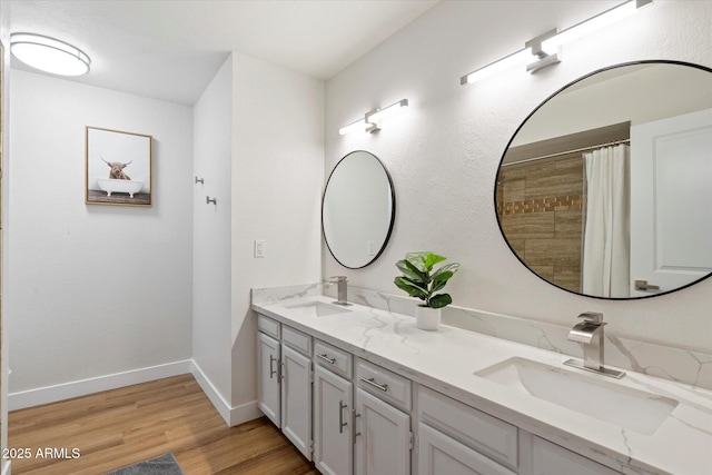 6271 E Evans Dr, Scottsdale, AZ 85254 - bathroom featuring wood finished floors, double vanity, a sink, and baseboards
