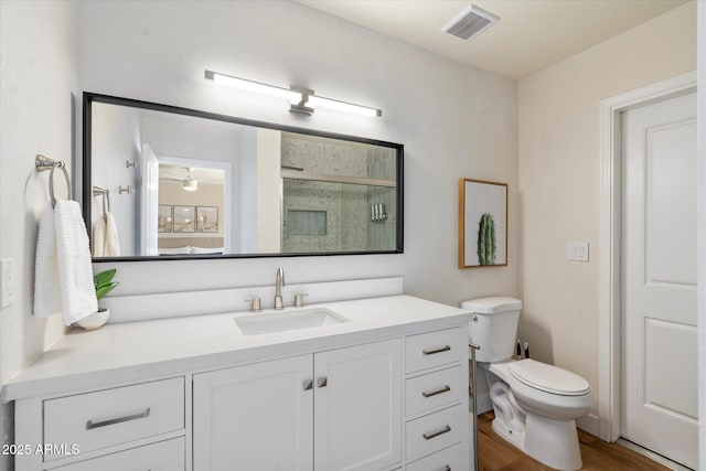 6271 E Evans Dr, Scottsdale, AZ 85254 - bathroom featuring vanity, visible vents, toilet, wood finished floors, and a stall shower