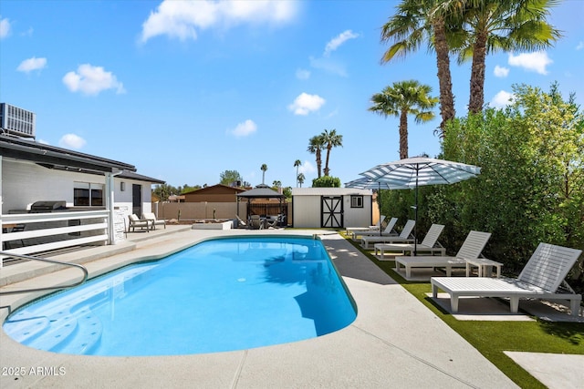 6271 E Evans Dr, Scottsdale, AZ 85254 - view of swimming pool featuring a shed, a patio area, central AC, a fenced backyard, and an outbuilding